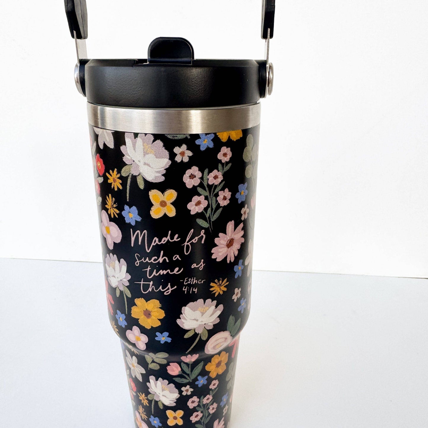 Floral-patterned tumbler with motivational quote on a white background