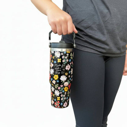 Person holding a floral-patterned tumbler with a plain background