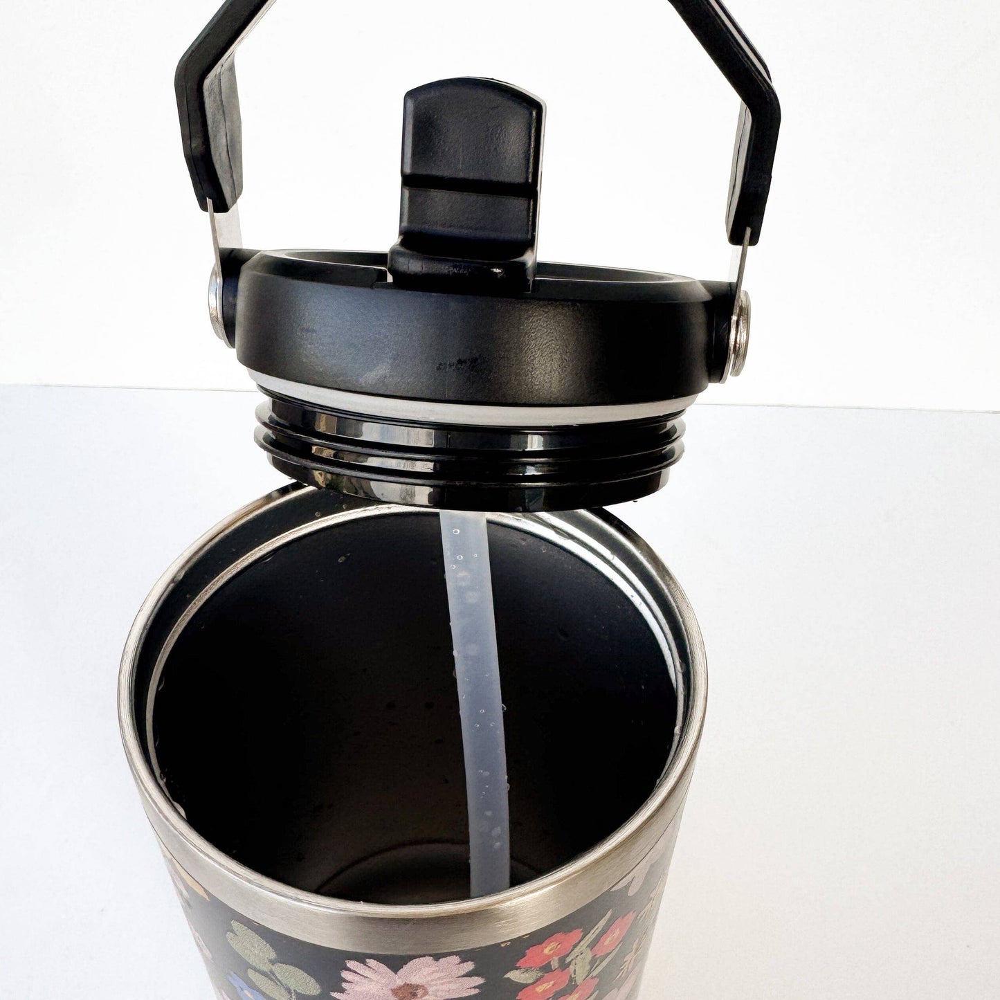 Floral-patterned water bottle with black lid on a white background