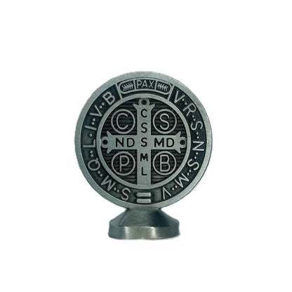 Metallic Benedict medal with religious symbols and text on a white background