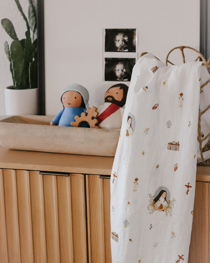 Baby crib with toys and a blanket featuring illustrations in a nursery setting
