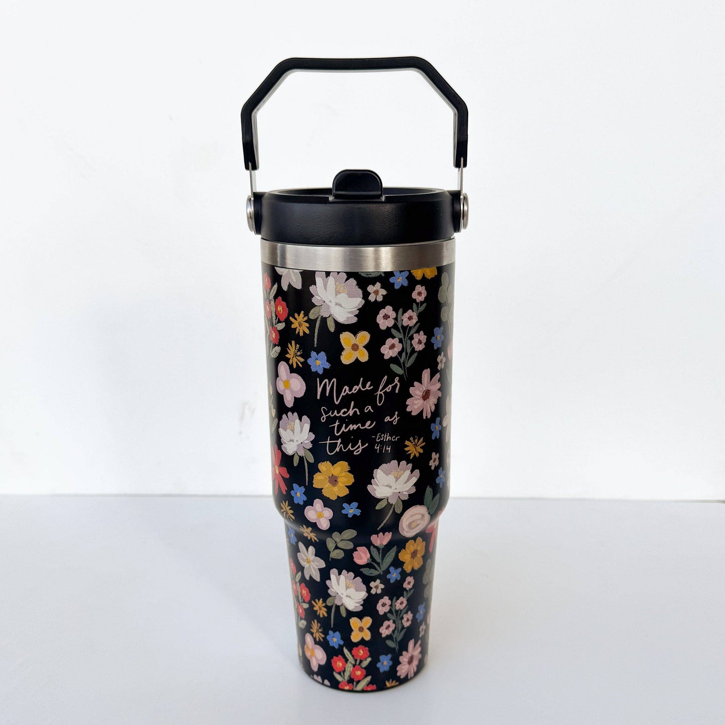 Floral-patterned tumbler with black lid on a white background