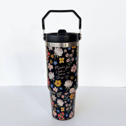 Floral-patterned tumbler with black lid on a white background
