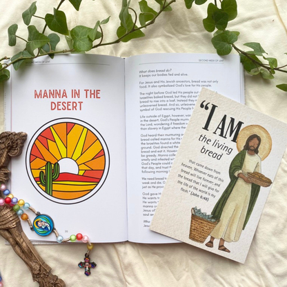 Open book with 'Manna in the Desert' illustration and a card with Jesus holding bread, surrounded by greenery and a cross.